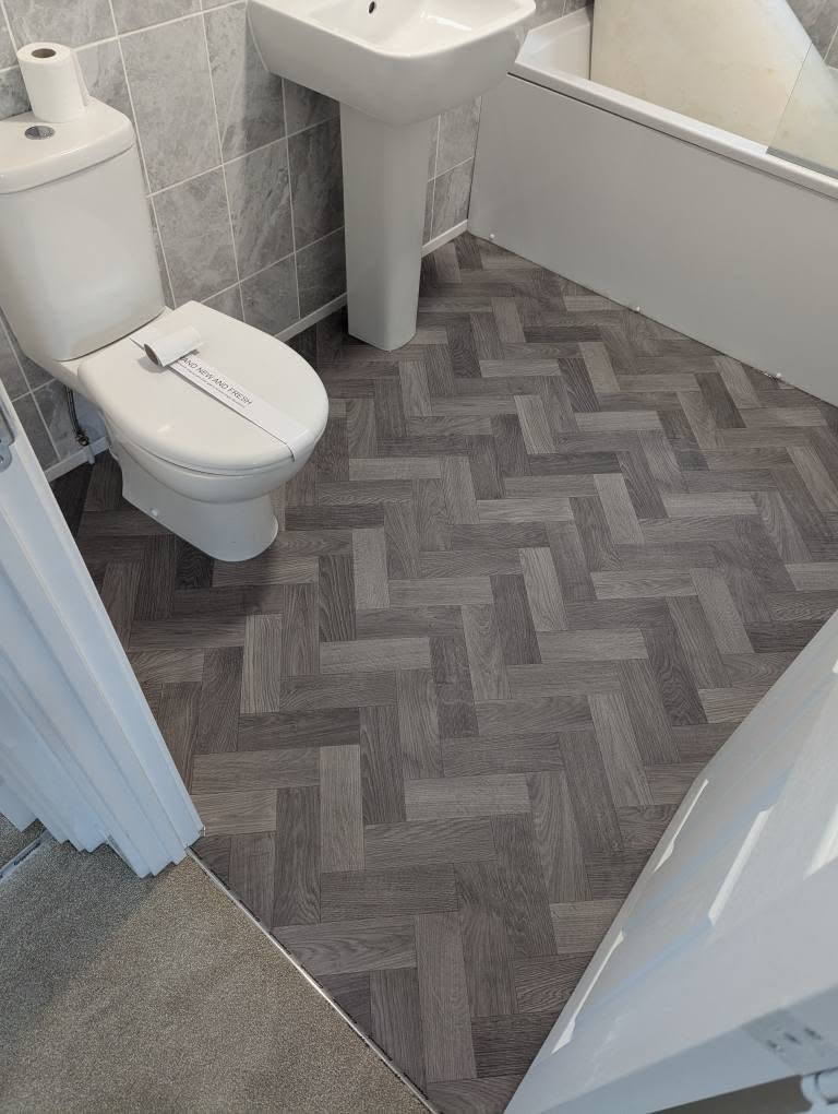 Grey herringbone vinyl flooring fitted in a Carlisle bathroom